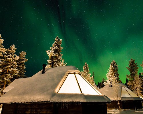 Glass domes standing in deep snow on an open hillside at night - Aurora Village Ivalo, Ivalo, Finland